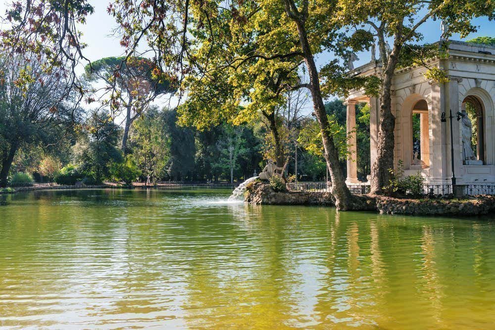 Plan d'eau entouré d'arbres et d'un temple à droite