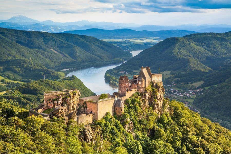 A castle overlooking a mountainous river valley in the Danube valley, Austria