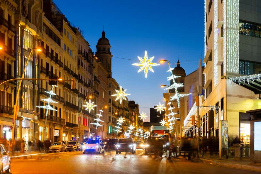 Calles de Barcelona al anochecer iluminadas por la decoración navideña