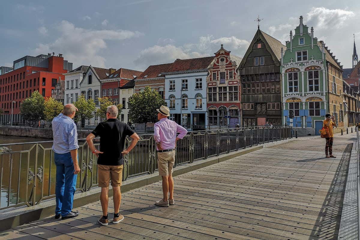 Trois hommes sur un pont observant l'architecture des bâtiments de la ville de Malines