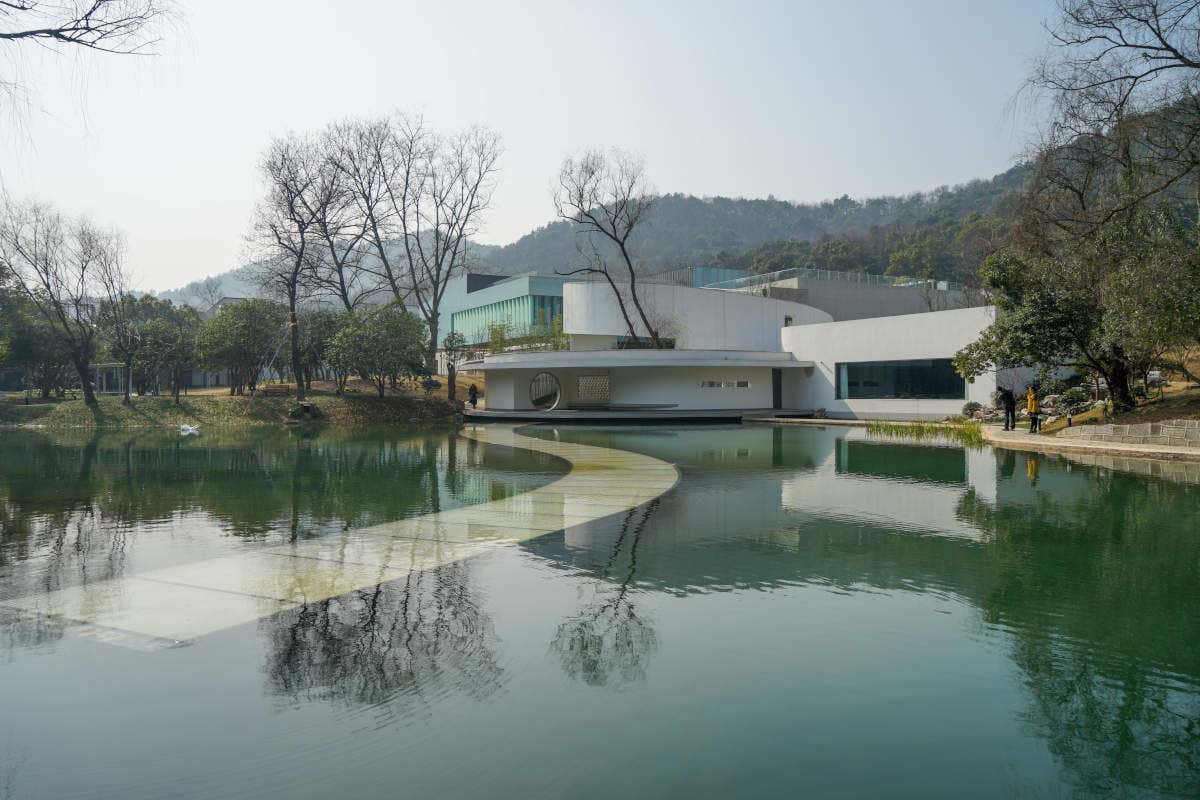 Panorámica del edificio del Museo Nacional de la Seda de China y del lago que le rodea