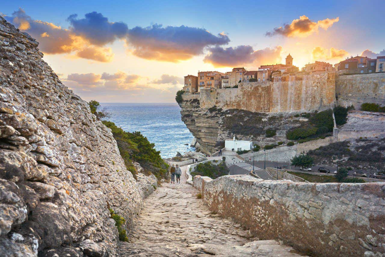 Coucher de soleil sur Bonifacio, en Corse, avec des maisons construites au bord de la falaise, un endroit à visiter absolument en France