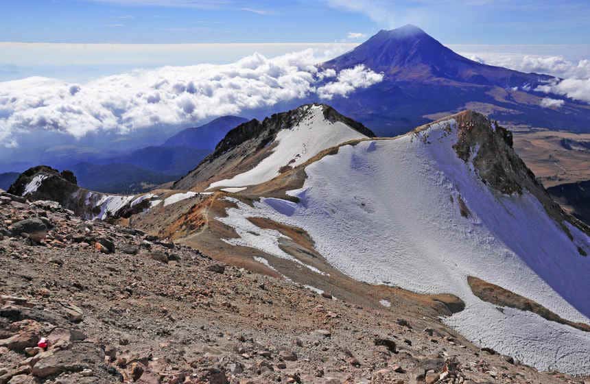 Iztaccíhuatl and Popocatépetl Volcanoes under a cloudy sky.