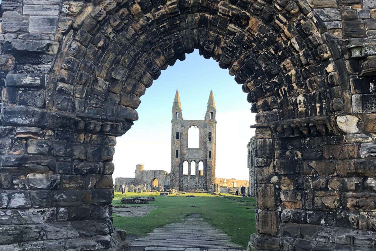 Imagem das ruínas da Catedral de Saint Andrews atrás de um arco