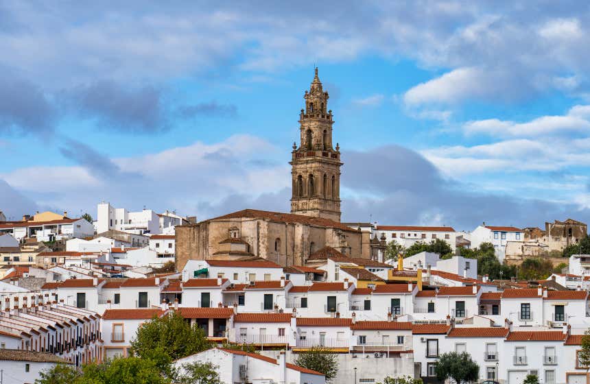 Torre de la iglesia de Santa Catalina de Jerez de los Caballeros rodeada de casas del municipio.