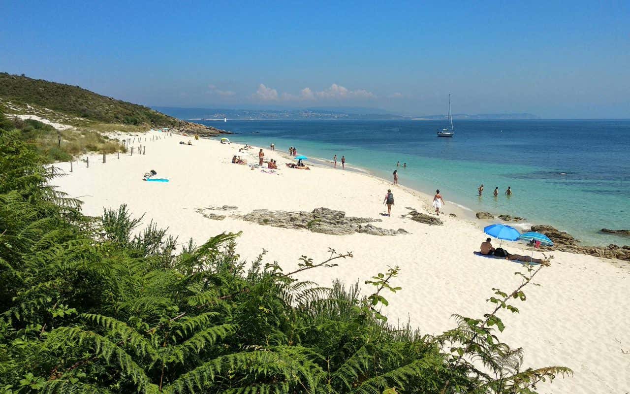 Turistas nas areias brancas da Praia de Melide