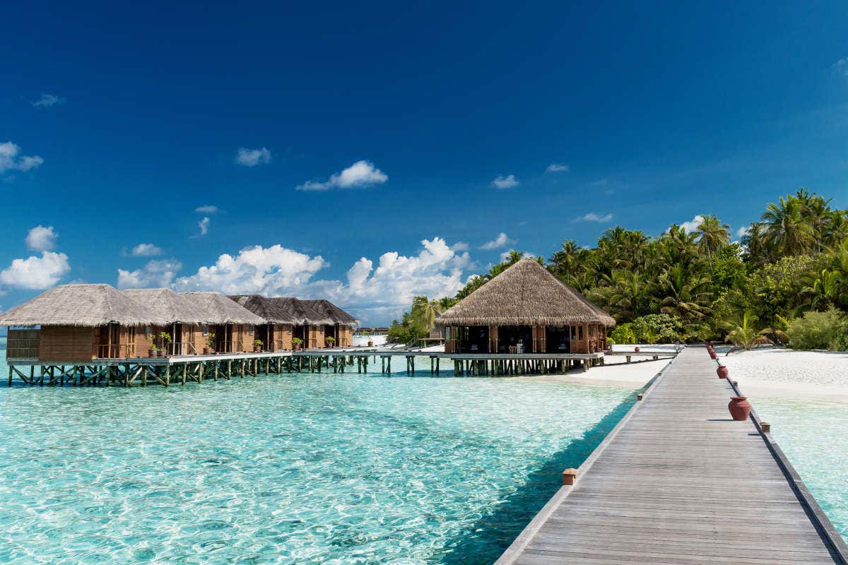 Una bellissima spiaggia tropicale, con acque cristalline e alcune capanne con il tetto di paglia