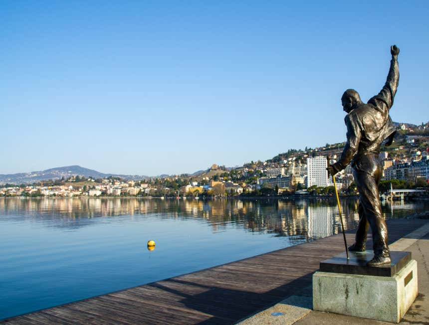 La statua di Freddy Mercury con il braccio alzato, affacciata sulle sponde del lago