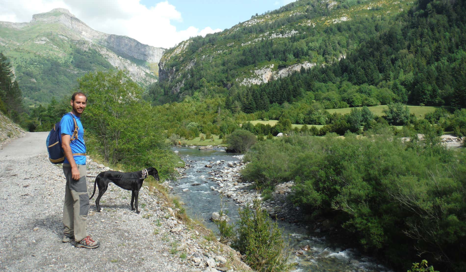 David Chaves con su perro junto a un arroyo entre las montañas del Parque Nacional Ordesa y Monte Perdido.