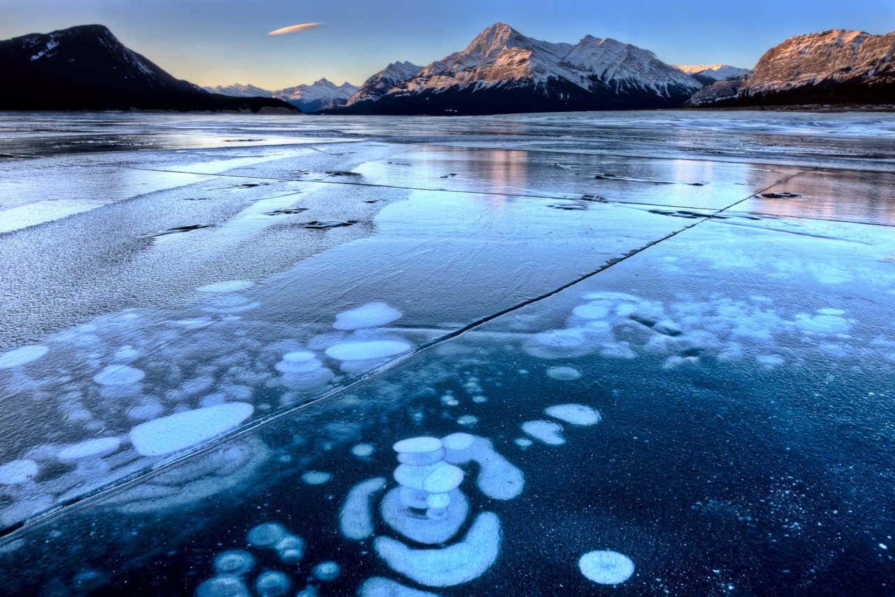 Lago Abraham con la superficie llena de burbujas congeladas y las montañas de fondo