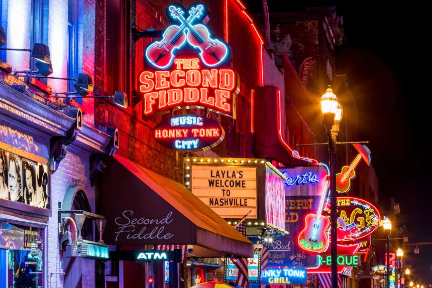 Calle iluminada con carteles de neón en Nashville.