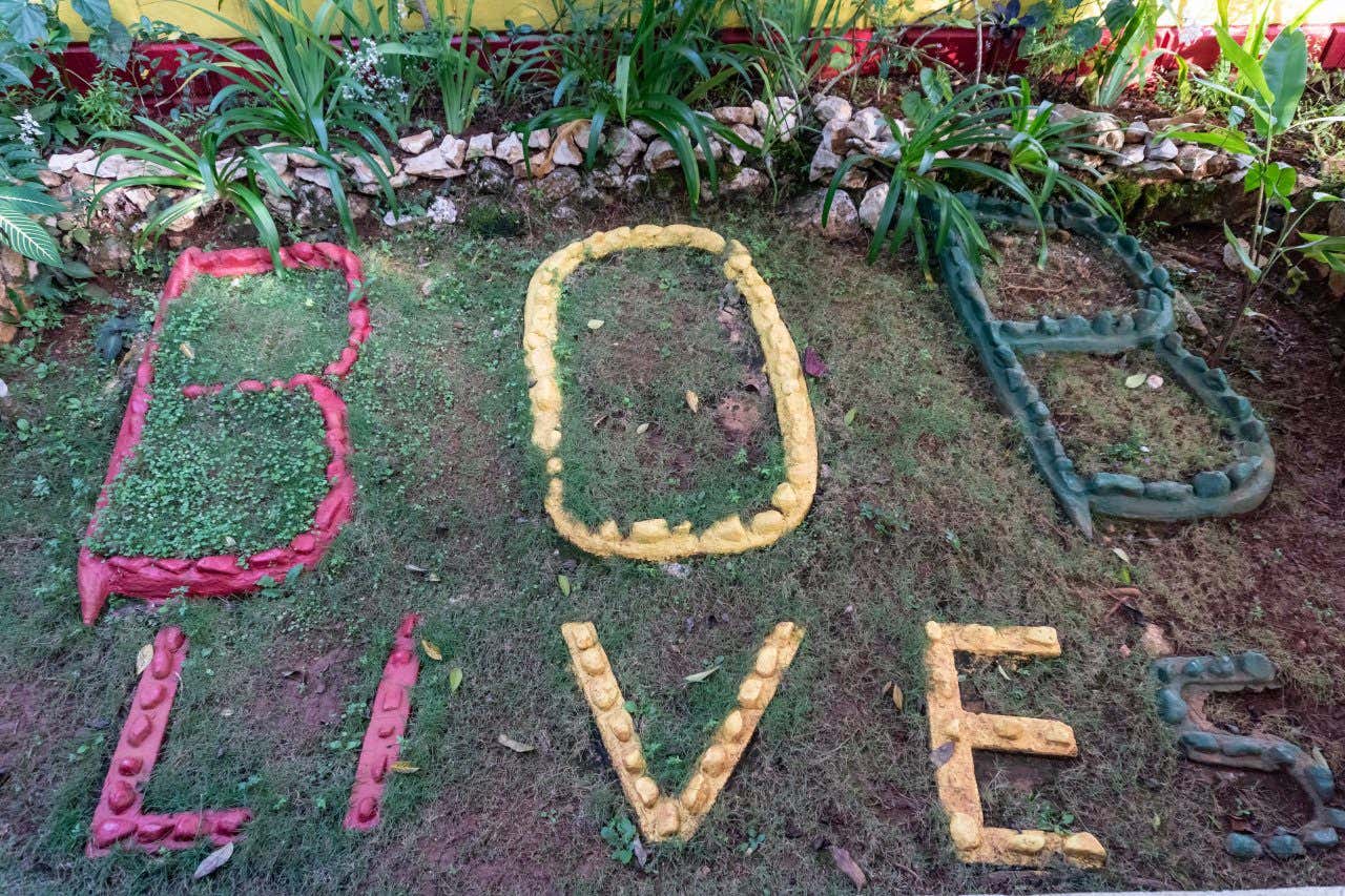 "Bob lives" écrit avec des pierres de couleur sur l'herbe en hommage à Bob Marley