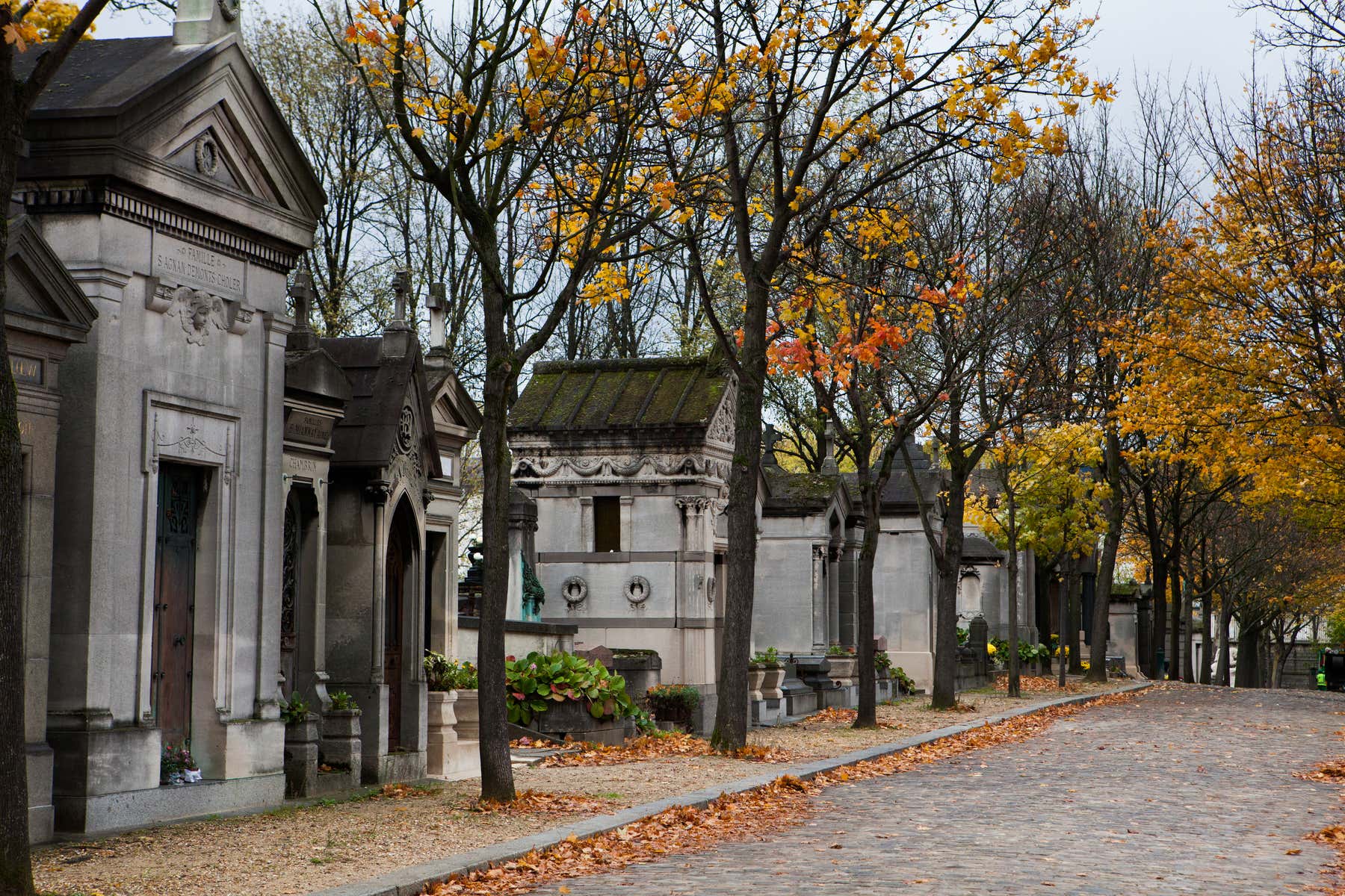 Vista de varias tumbas en un cementerio en París en un día otoñal