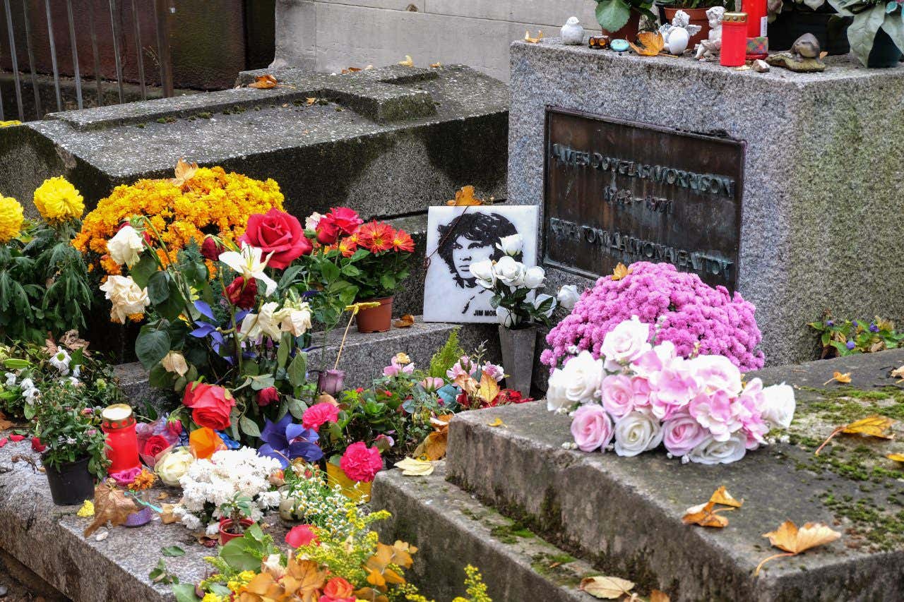 Tombe de Jim Morrison ornée d'une photo du chanteur et de fleurs au cimetière du Père-Lachaise, l'une des tombes les plus célèbres dans le monde