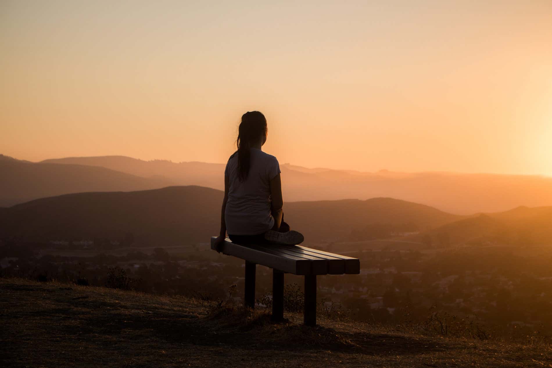 Mujer mirando al horizonte durante el atardecer