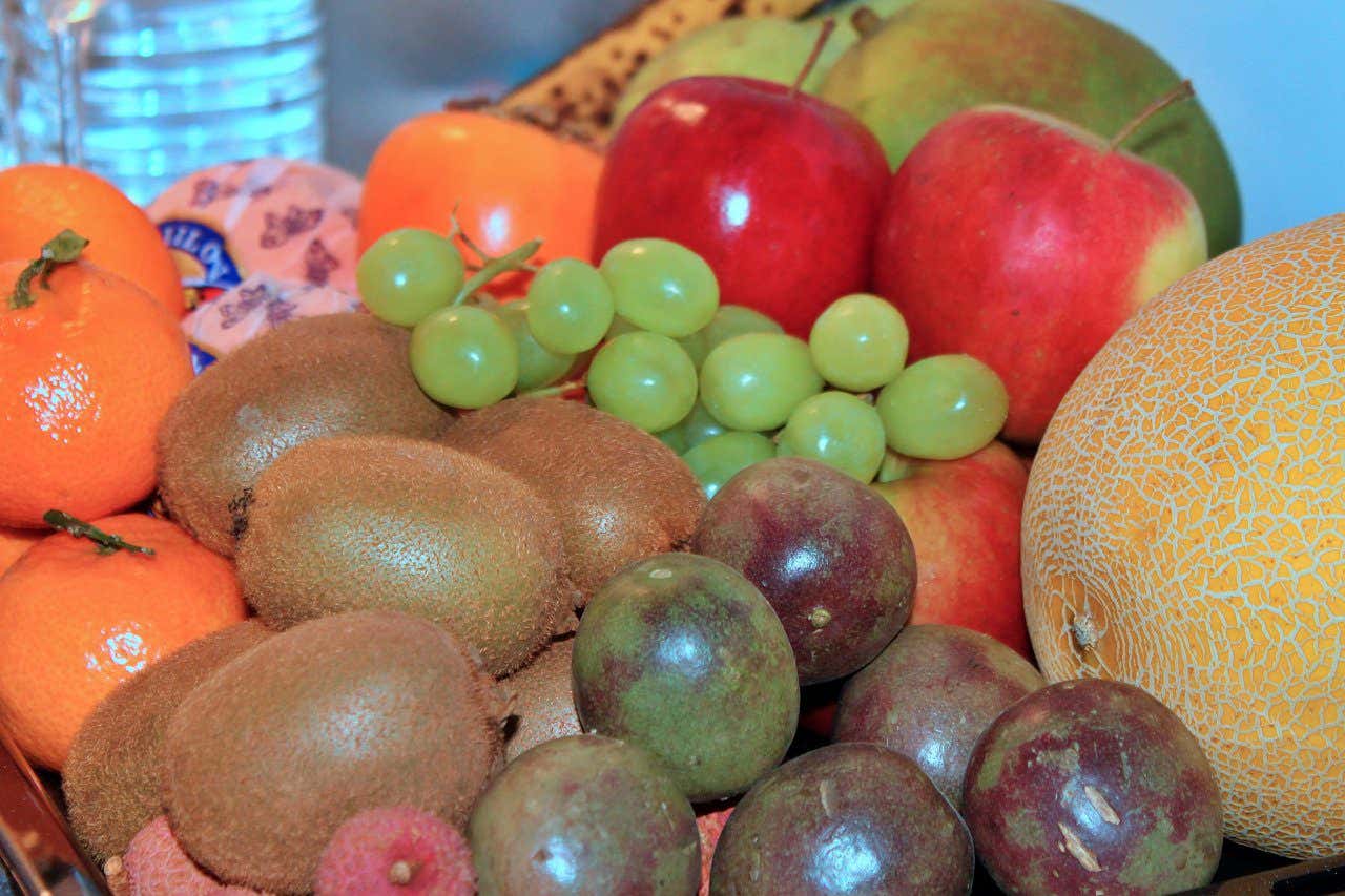 A large collection of kiwis, oranges, grapes, apples, melons, passion fruit and lychees