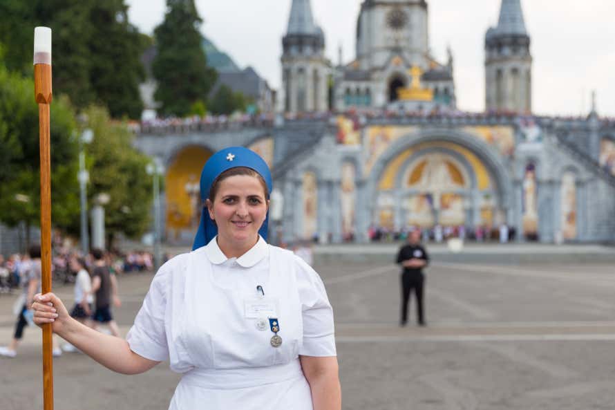 Mulher em frente ao santuário de Lourdes, França