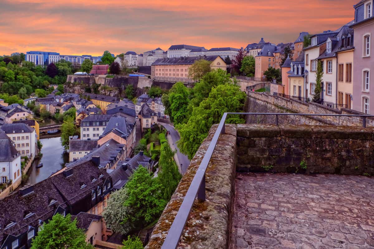 Chemin de la Corniche at sunset with views of many roofed houses and a stone bridge