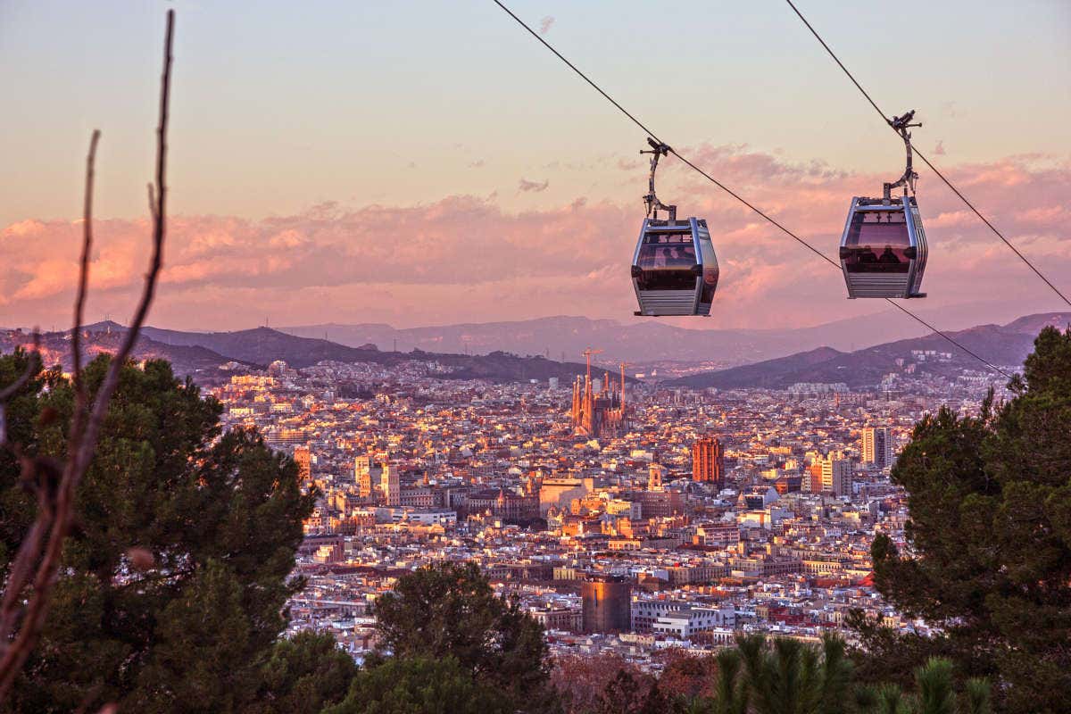 Barcelona y su teleférico bajo los colores morados del atardecer