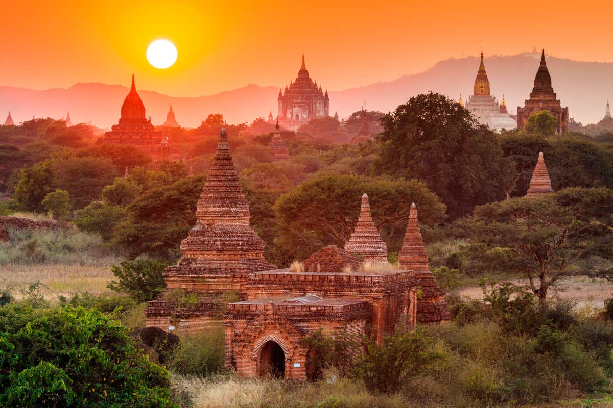 El valle de Bagan con sus típicos templos mientras el sol empieza a iluminar la escena al amanecer.