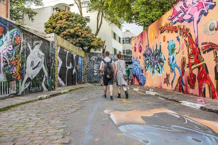 Couple se promenant parmi les peintures murales colorées de Beco do Batman