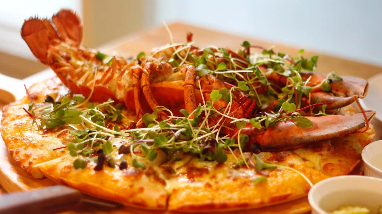 A lobster pizza with herbs on top