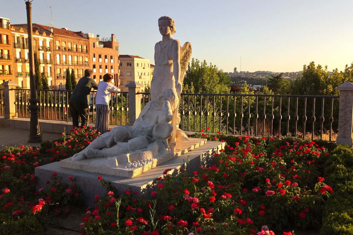 Esculturas en el mirador del parque de San Francisco en Madrid con dos personas contemplando las vistas al fondo.