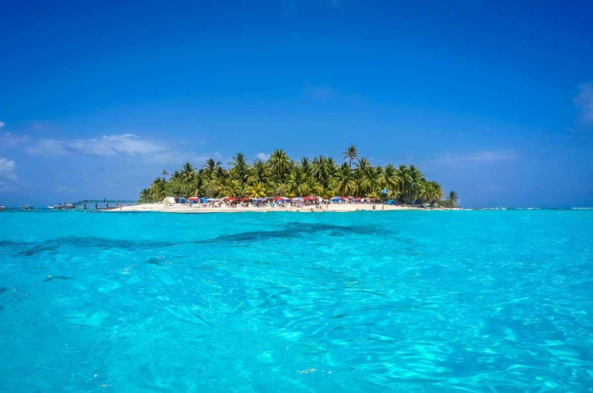 Água cristalina e, ao fundo, a Ilha San Andrés e suas palmeiras, uma das melhores praias da Colômbia