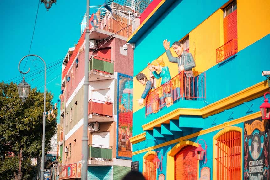 Edificios coloridos con personas argentinos en las fachadas en Caminito