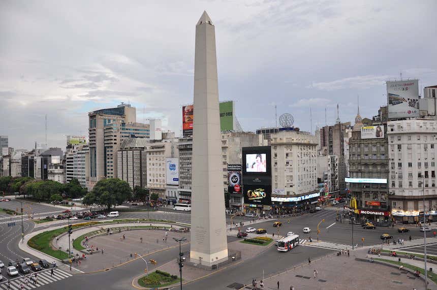 Uno de los lugares que ver en Buenos Aires es el Obelisco situado en el centro de la Avenida 9 de Julio, con numerosos coches y turistas en el paisaje