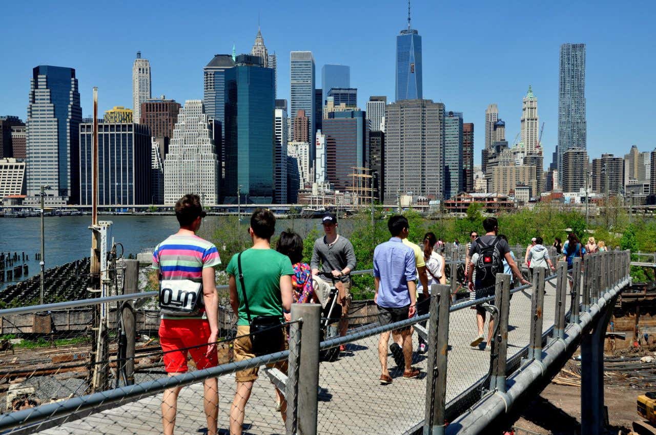 Persone che camminano lungo il ponte Squibb Park Bridge in una giornata di sole