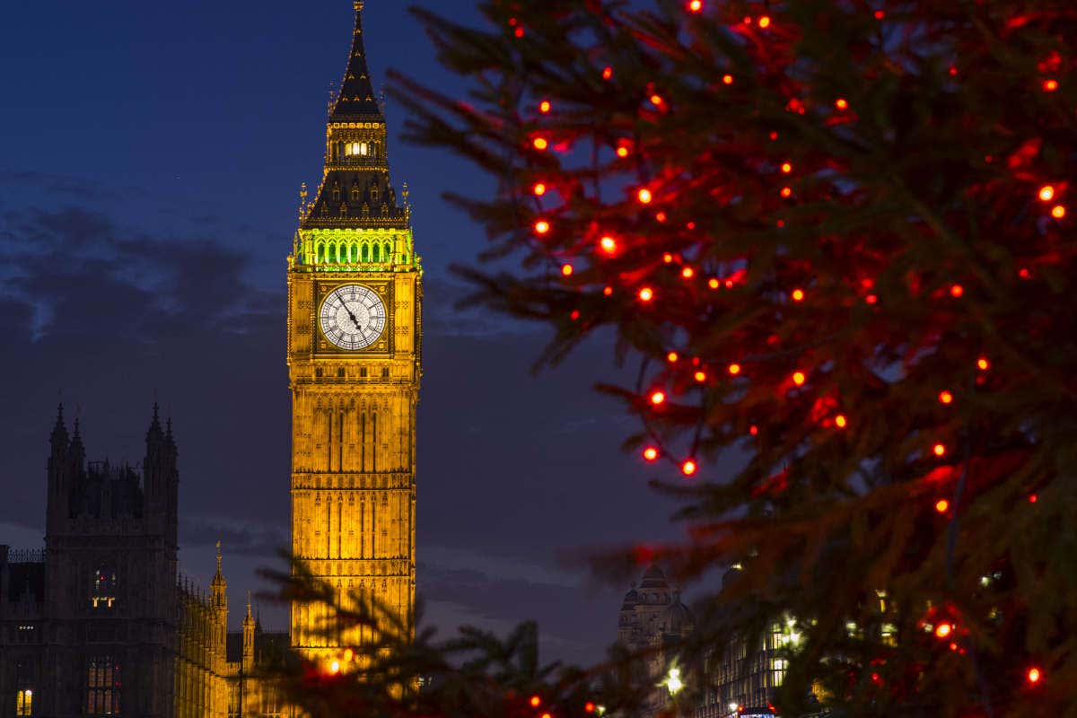 O Big Ben iluminado com árvores com decoração de Natal