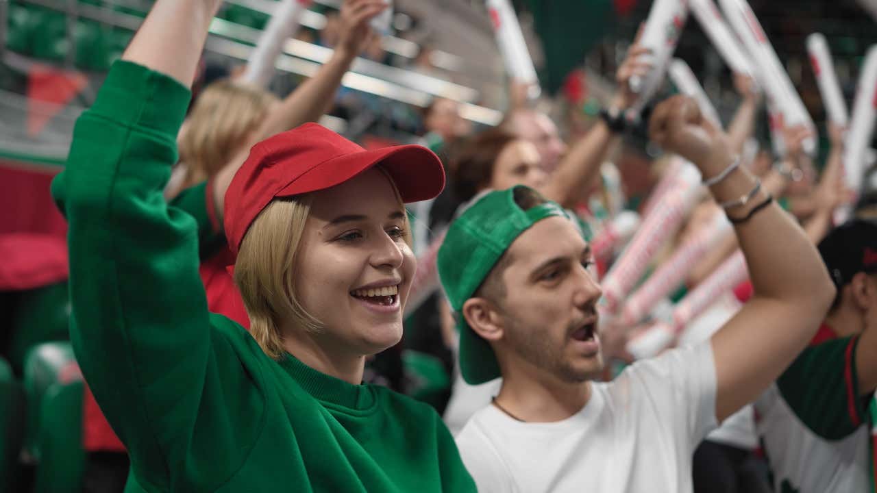 Deux fans de sport encourageant leur équipe dans les gradins d'un stade