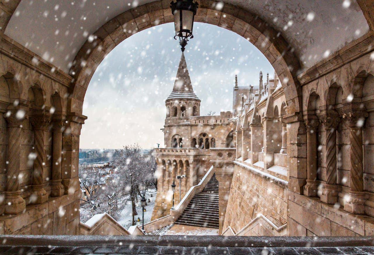 Shot through an arch window of Budapest on a snowy day