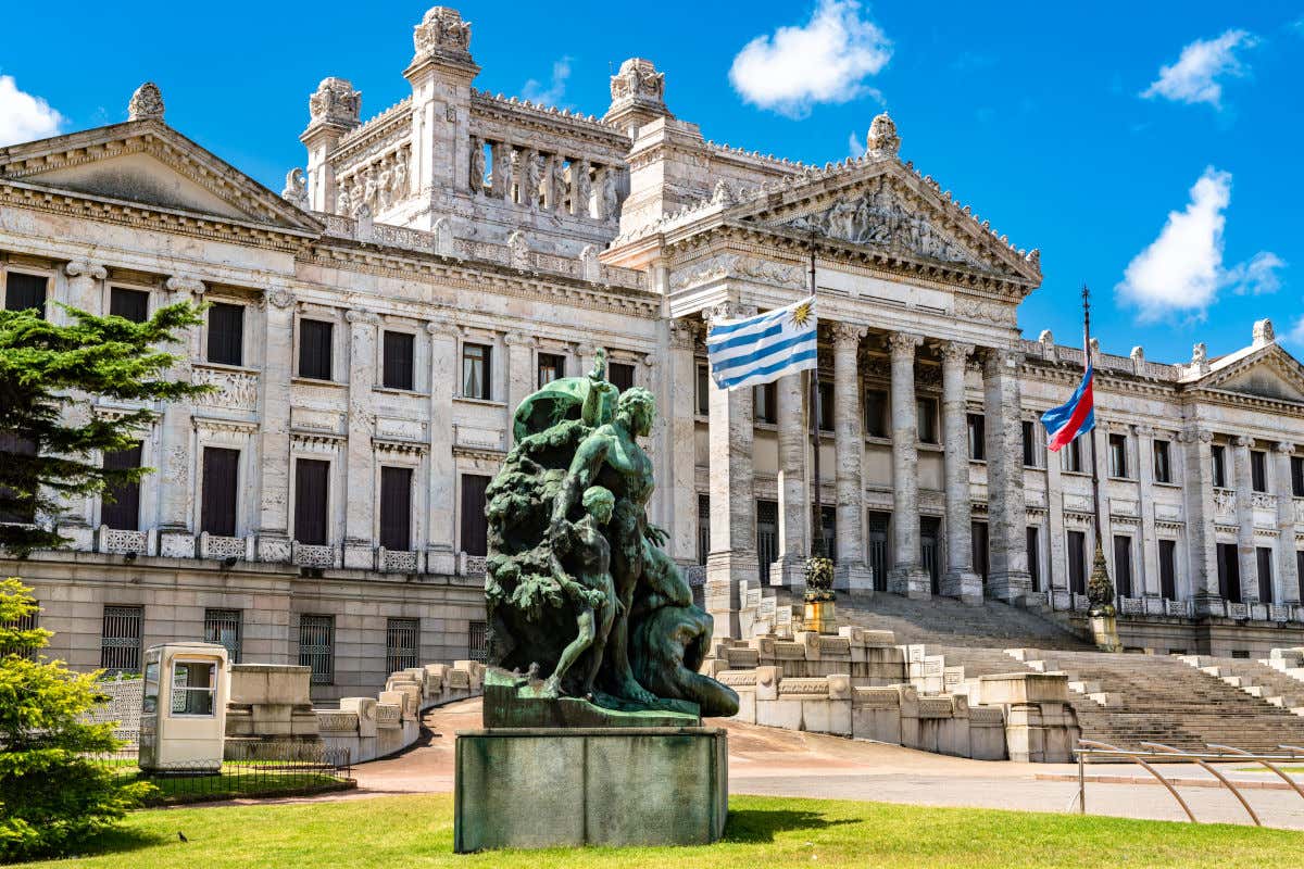 Vista frontal del Parlamento del Uruguay en Montevideo decorado con dos banderas y un conjunto escultórico junto a su pórtico