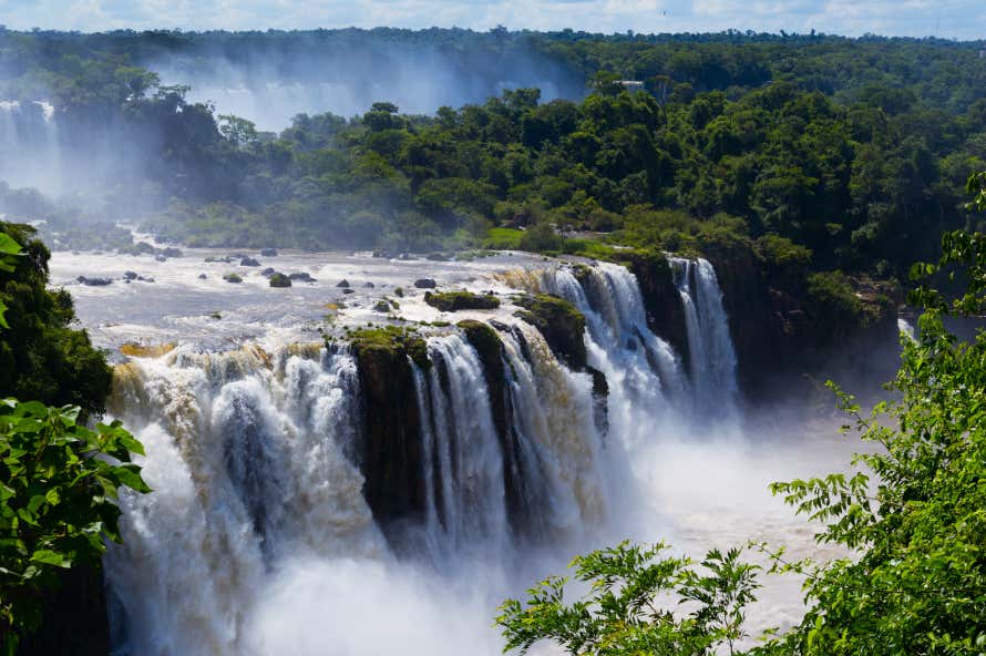 Cataratas do Iguaçu com uma vegetação densa ao fundo