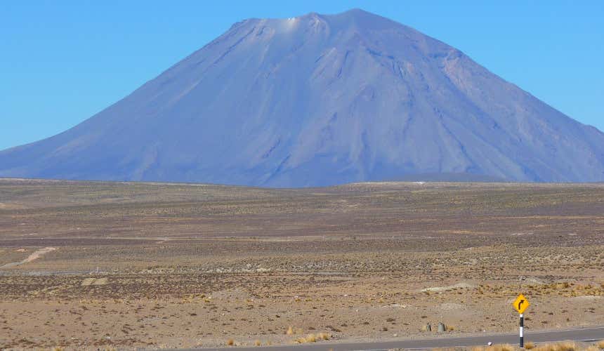 O vulcão Misti em um dia ensolarado, se eleva no meio de uma extensão desértica