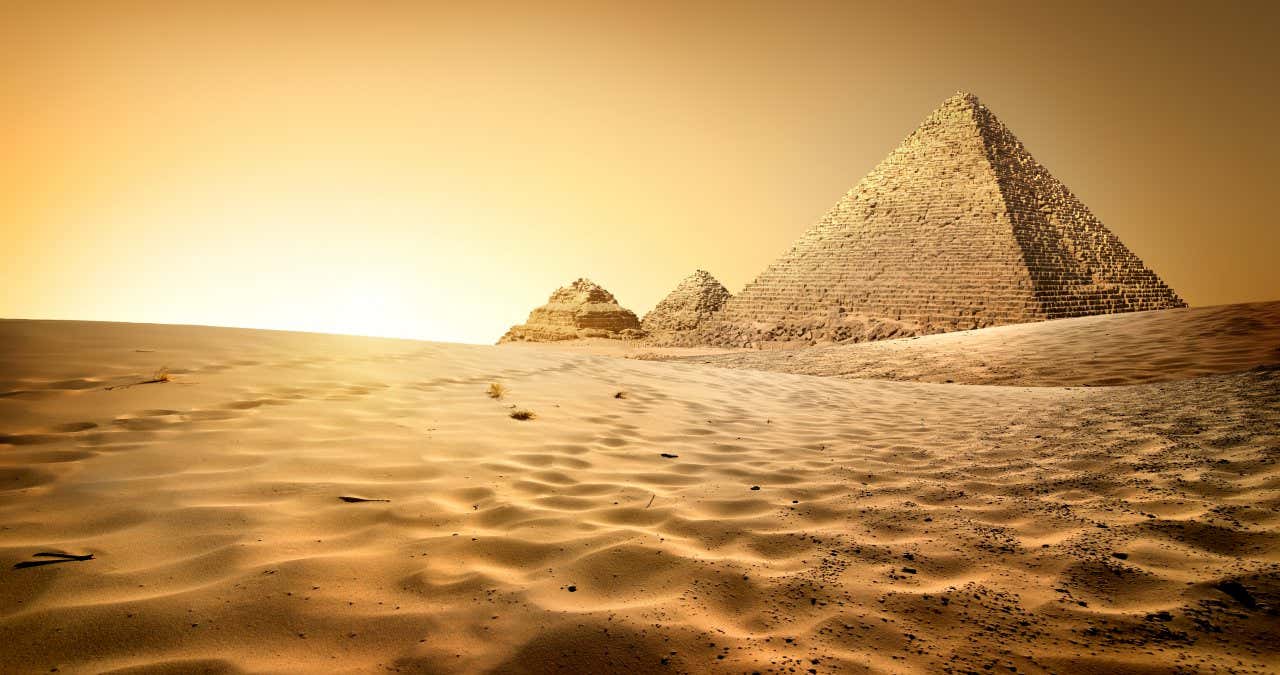 Pirámides de Giza rodeadas de arena en Egipto al atardecer