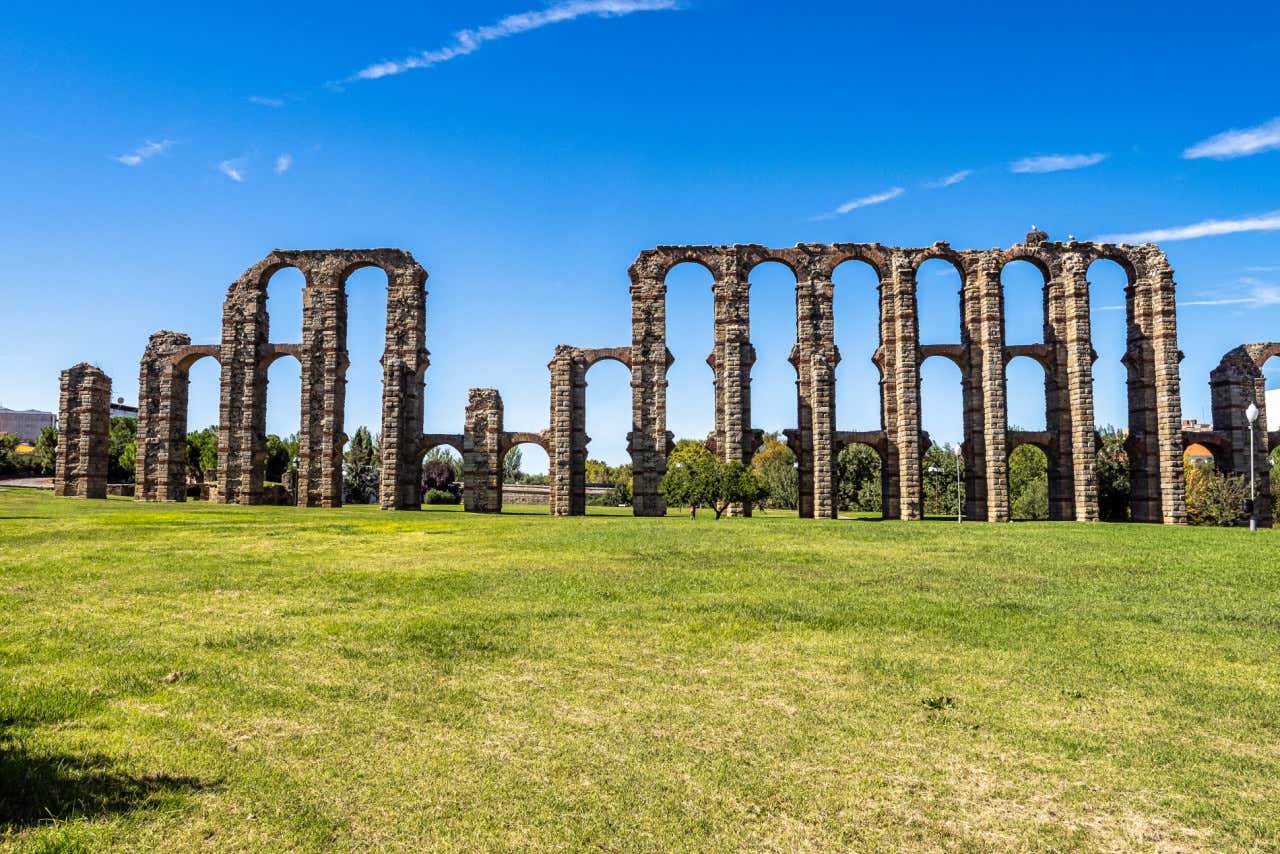 Vista frontal del Acueducto de los Milagros, una gran obra de ingeniería en una explanada de césped de grandes dimensiones