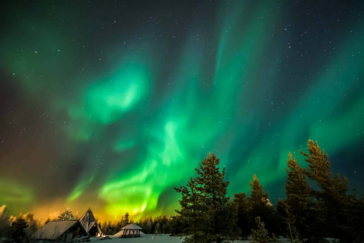 Cielo notturno stellato con toni verdi e gialli tipici dell'aurora boreale di Rovaniemi, in Lapponia