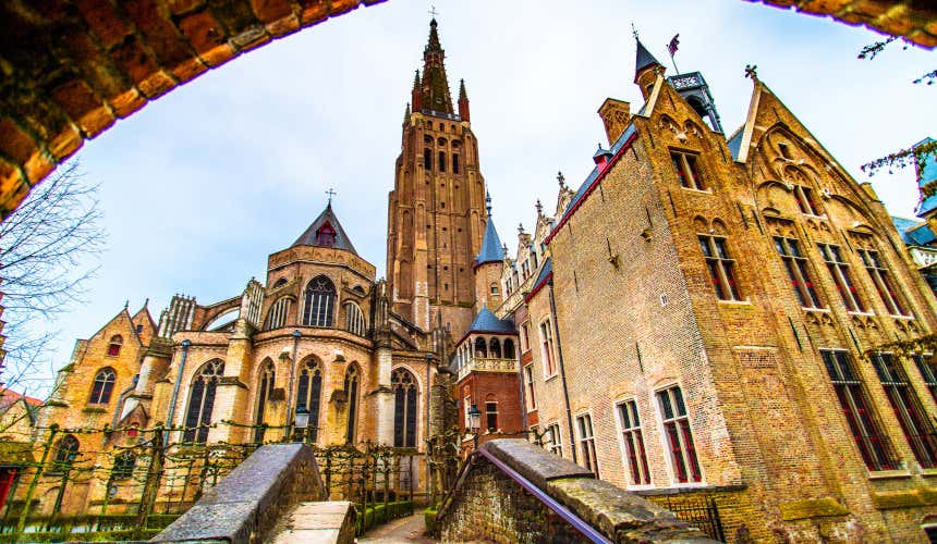 Vista sul Campanile e chiesa di Nostra Signora a Bruges a cui si arriva lungo un ponte in pietra