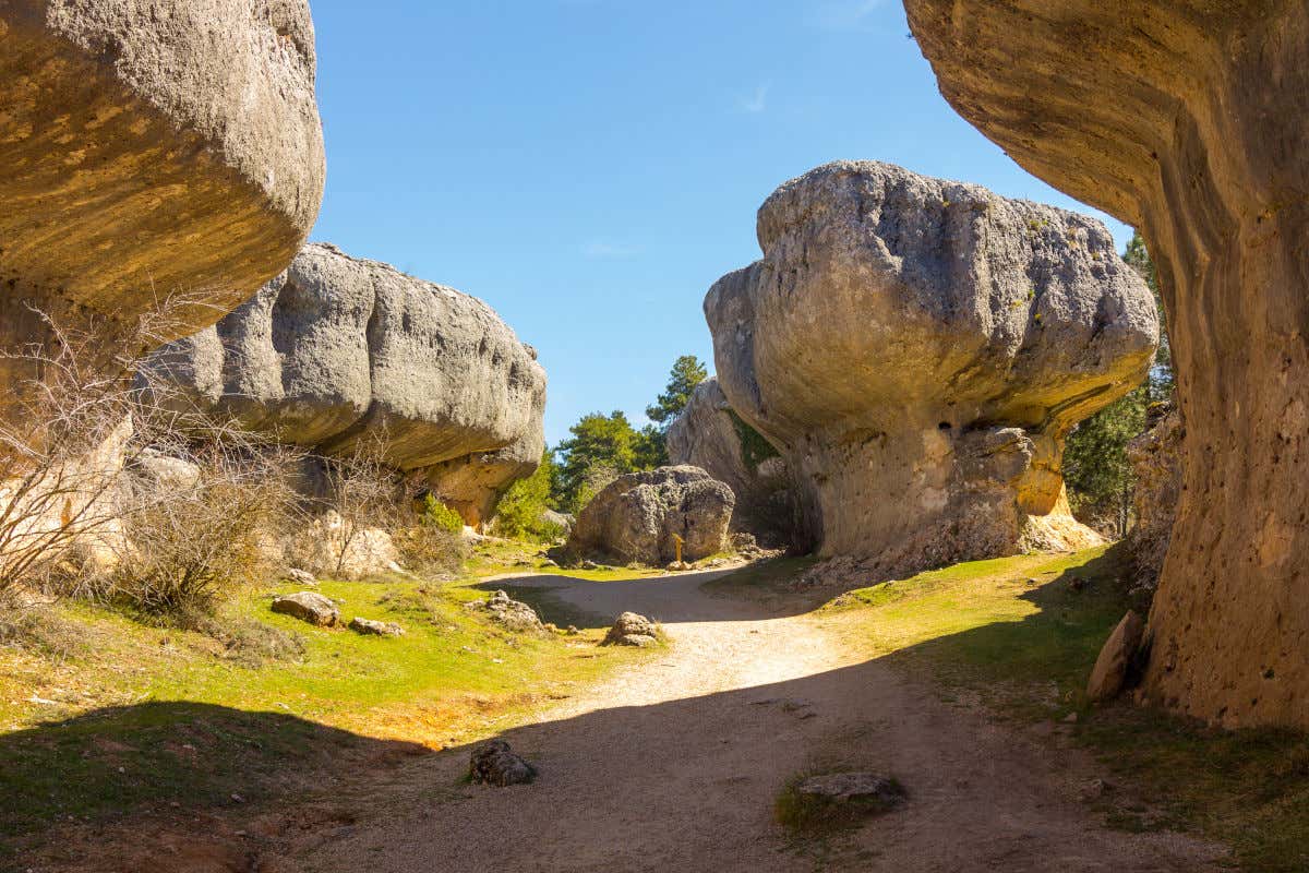 Curiosas formaciones rocosas junto a un camino de arena y piedra en la Ciudad Encantada de Cuenca