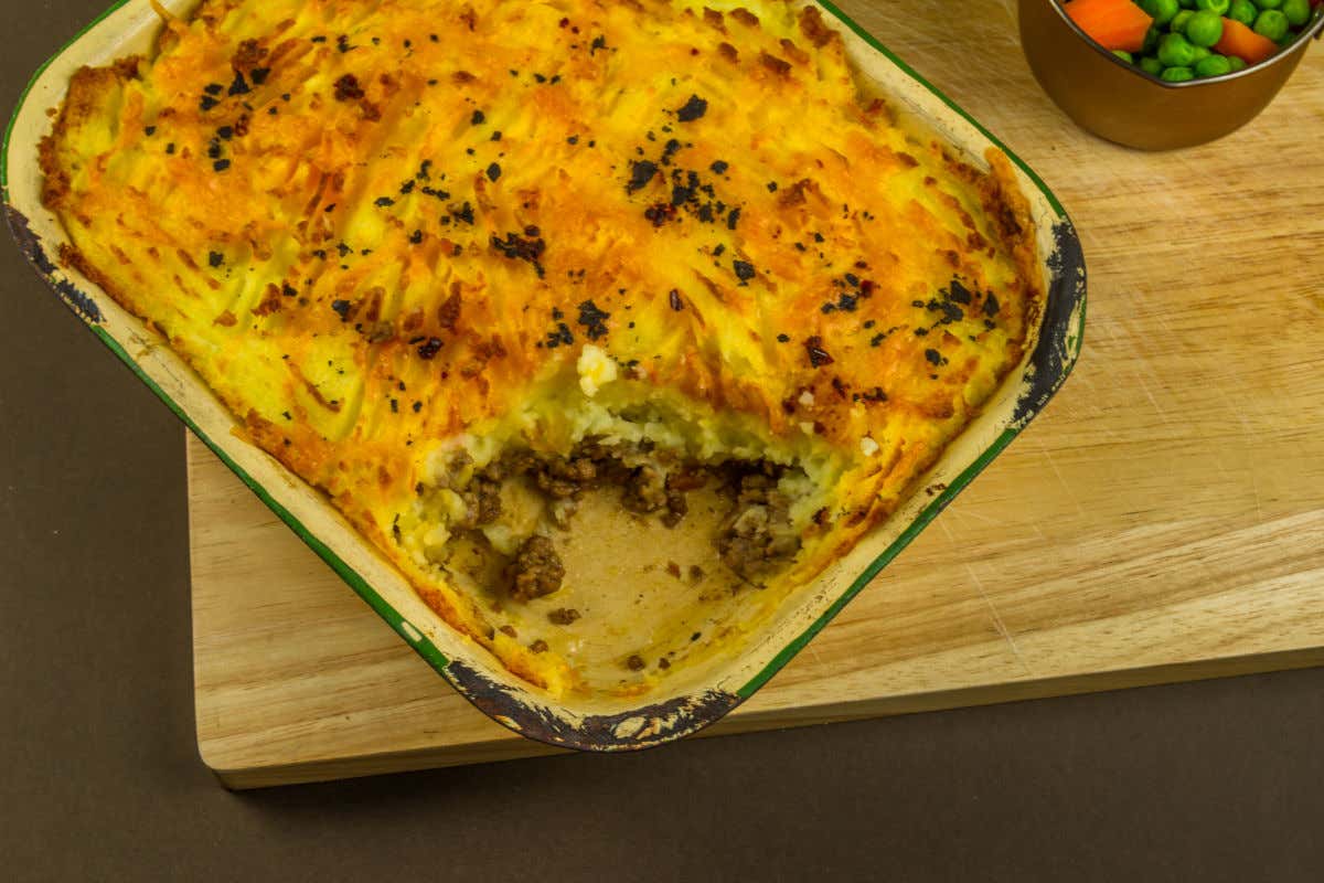 Pirofila con cottage pie, un pasticcio di carne tipico dell'Inghilterra, a cui manca un pezzetto