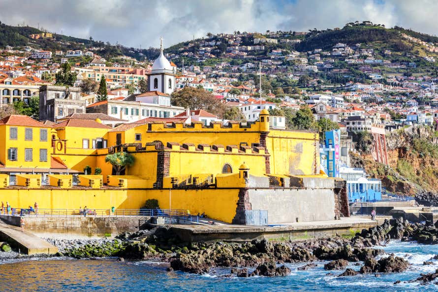 Castillo de Funchal que contrasta por su color amarillo con el resto de casas de la ciudad y las orillas del mar