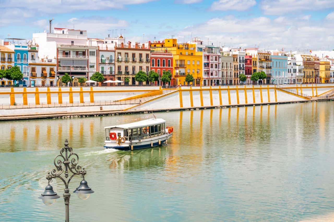 Barco recorriendo el Guadalquiver en Sevilla en un día de sol