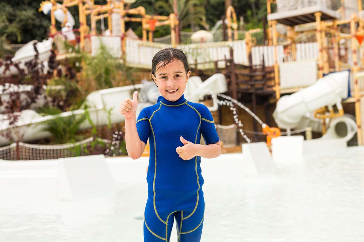 Una niña sonriente mirando a la cámara frente a la zona infantil del Siam Park, uno de los parques acuáticos más importantes del mundo