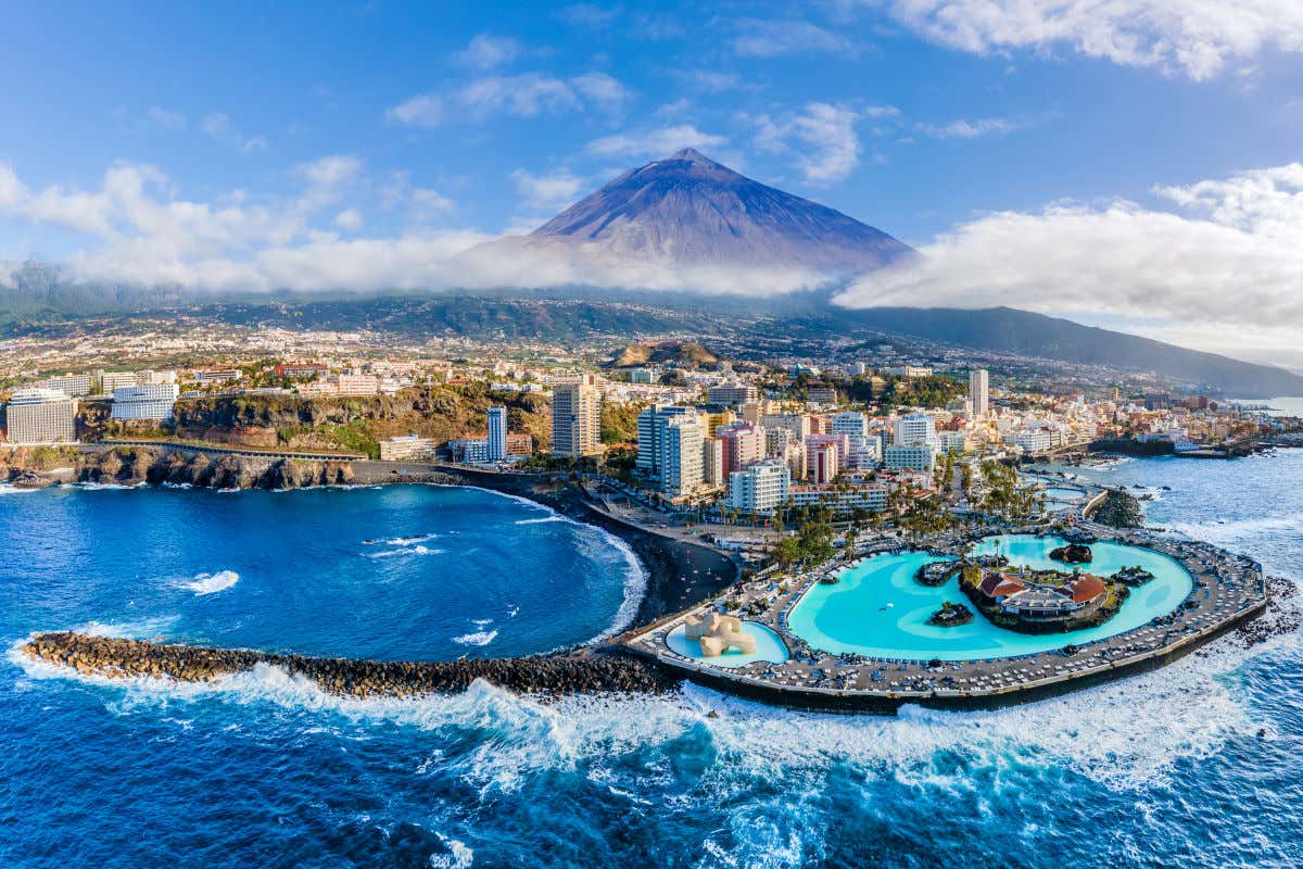 Panorámica del norte de Tenerife con el Teide al fondo y el Puerto de la Cruz con el famoso Lago Martiánez en primer plano