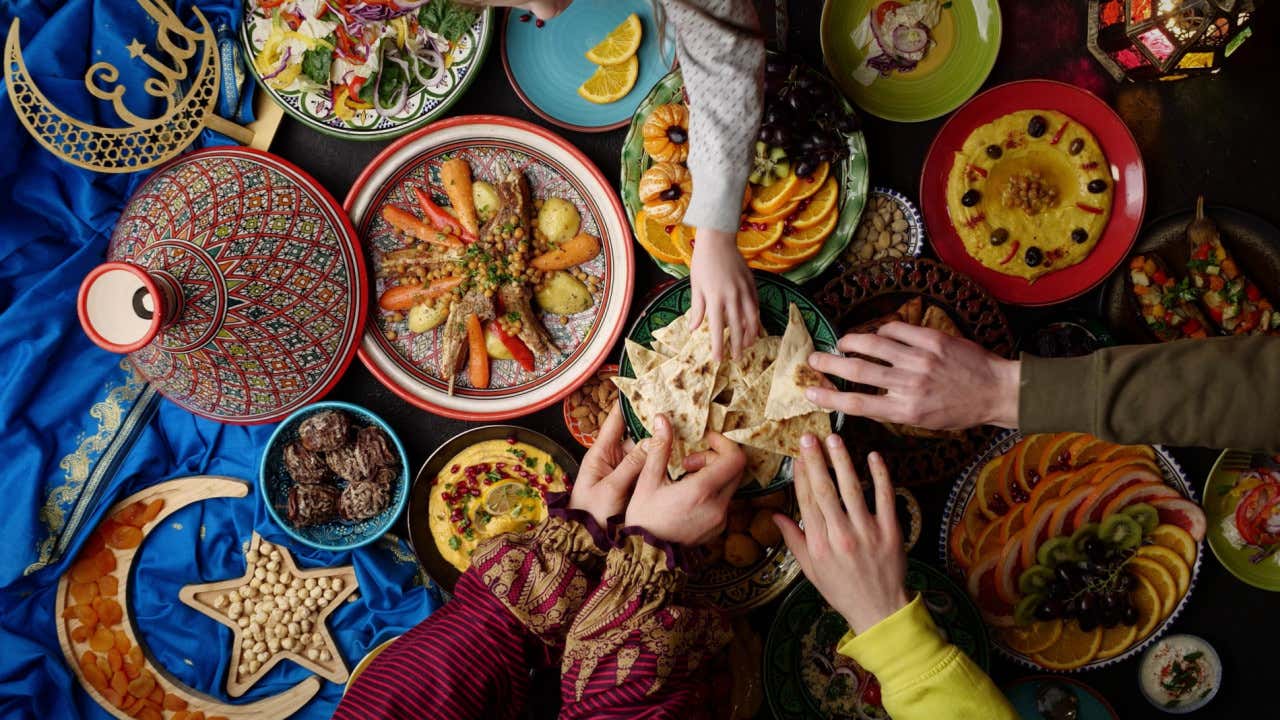 Varios platos típicos de la gastronomía marroquí, como el tajín y el cuscús, sobre una mesa colorida