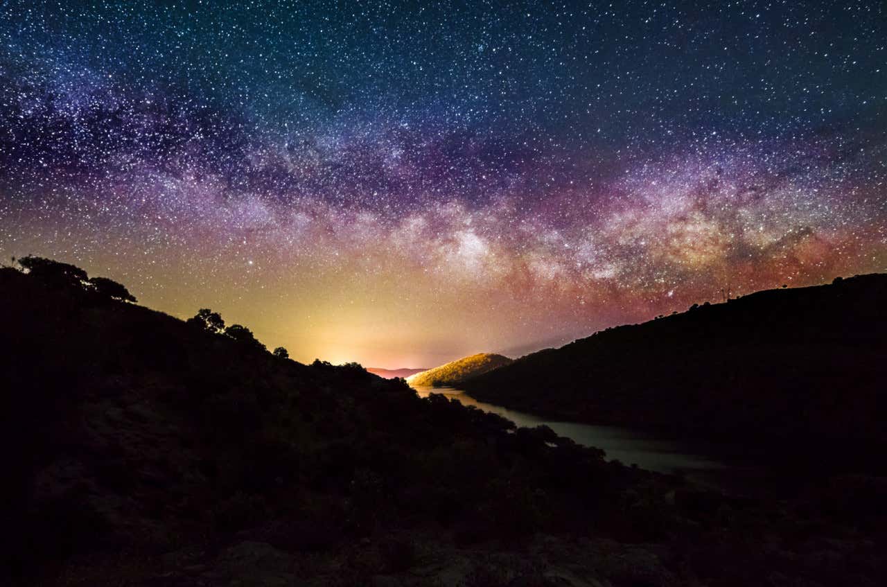 Vista panorámica del Parque Nacional de Monfragüe donde se aprecia el cielo nocturno lleno de estrellas