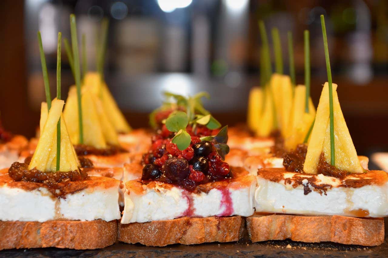 Pintxos de tartines de pain avec fromage et différents fruits, typique de la gastronomie du Pays basque espagnol